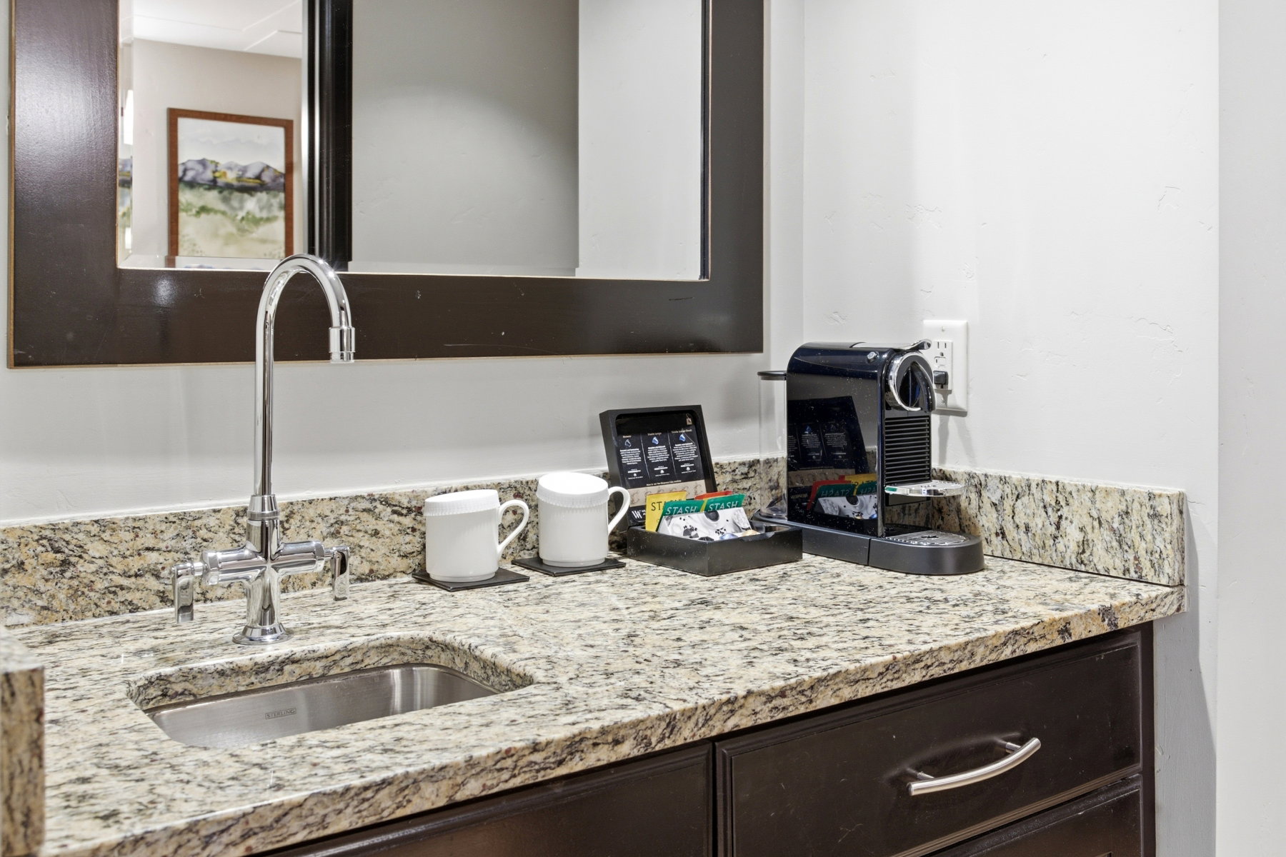 Kitchen with light stone counters and dark brown cabinets