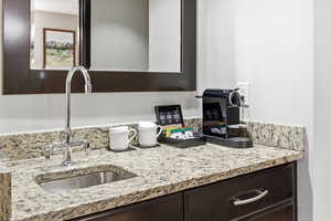 Kitchen with light stone counters and dark brown cabinets