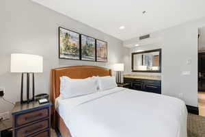 Carpeted bedroom with recessed lighting