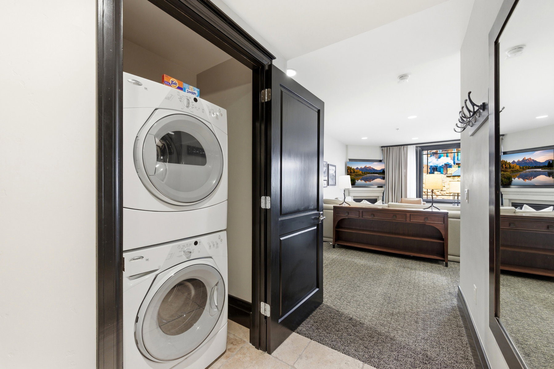 Laundry area with stacked washer and clothes dryer, light carpet, and recessed lighting