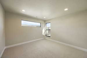 Unfurnished room featuring light carpet, recessed lighting, and a textured ceiling