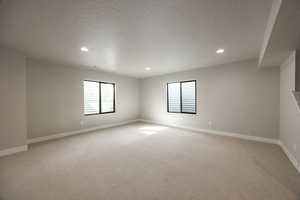 Spare room with light carpet, recessed lighting, and a textured ceiling