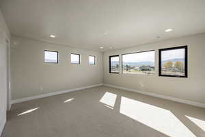 Spare room with light colored carpet, recessed lighting, and a mountain view