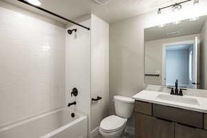 Bathroom with vanity,  shower combination, and a textured ceiling