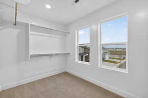 Spacious closet with light colored carpet
