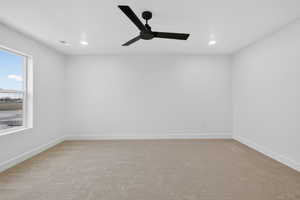 Empty room with light colored carpet, a ceiling fan, and recessed lighting