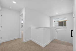 Corridor featuring an upstairs landing, light colored carpet, and recessed lighting