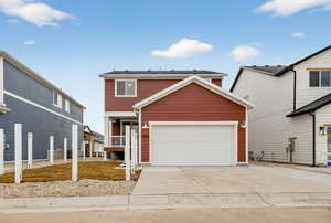 Traditional home featuring concrete driveway and an attached garage