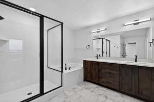 Bathroom featuring double vanity, a shower stall, a bath, and light marble finish floors