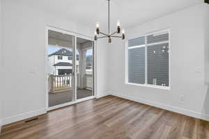 Unfurnished dining area featuring light wood-style flooring and a chandelier