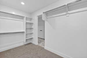 Walk in closet with light colored carpet