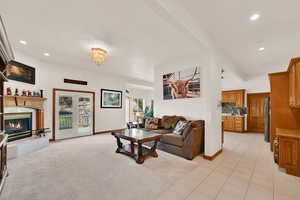Living area with recessed lighting, light tile patterned floors, light carpet, a fireplace, and a chandelier