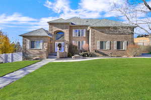 French country home with brick siding and roof with shingles