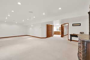 Finished below grade area with recessed lighting and light colored carpet