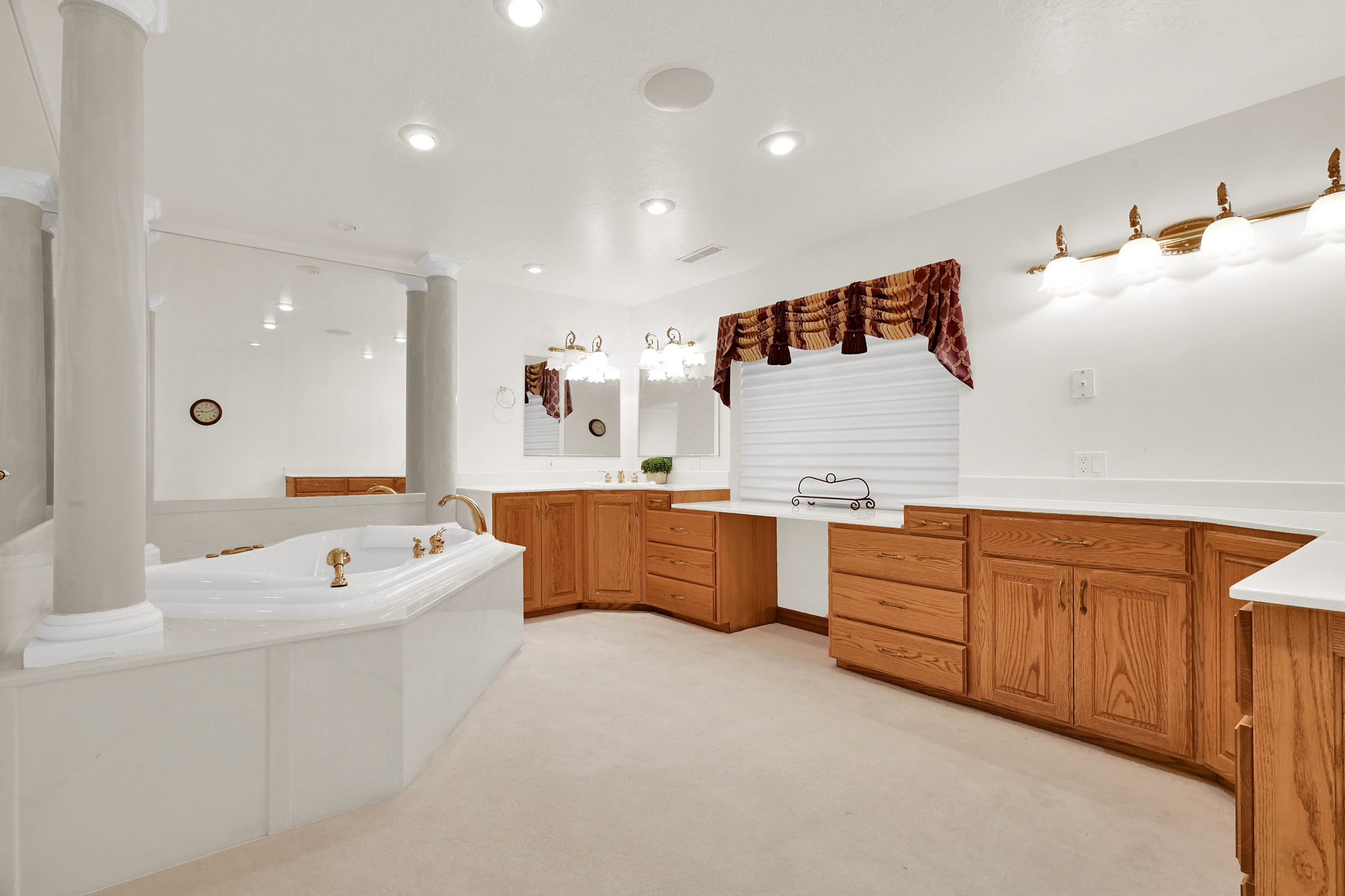Bathroom featuring vanity, a bath, light carpet, and recessed lighting