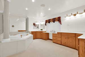 Bathroom featuring vanity, a bath, light carpet, and recessed lighting