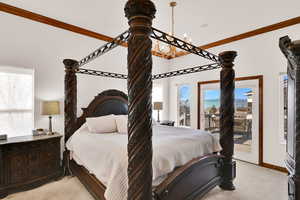 Bedroom with light carpet, access to outside, and crown molding