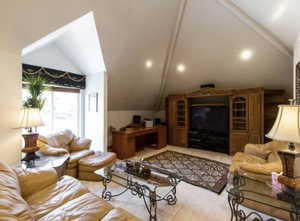 Living area with vaulted ceiling and recessed lighting