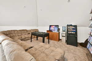 Rec room featuring light colored carpet and lofted ceiling