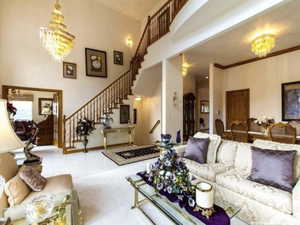 Living area with a chandelier, a towering ceiling, and stairway