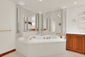 Full bathroom featuring a garden tub and vanity