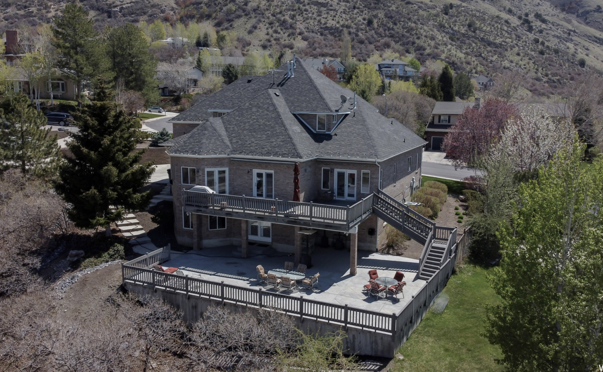 Back of property featuring a fenced backyard, roof with shingles, a deck, and a patio area with amazing views
