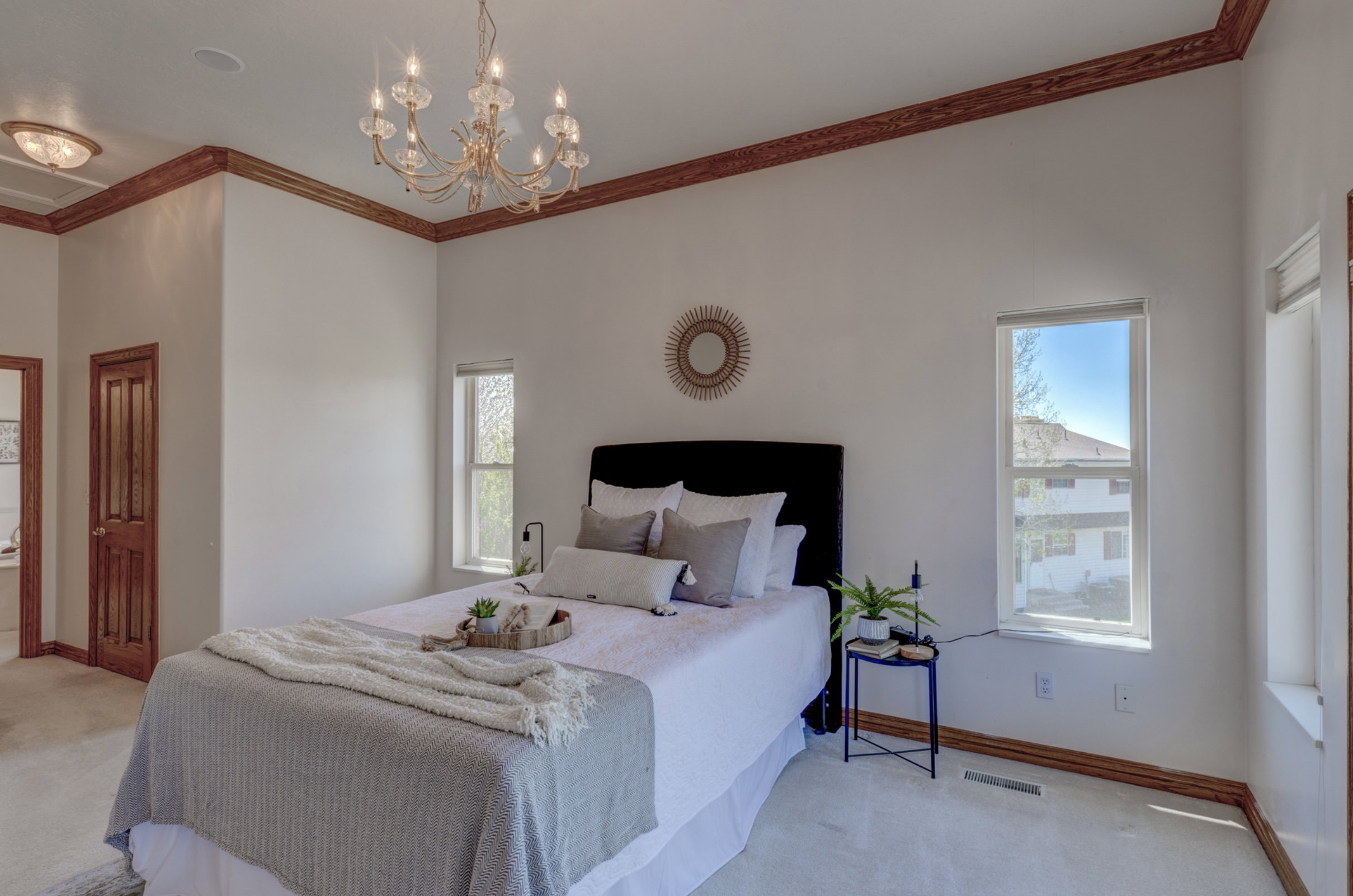 Bedroom with ornamental molding, a chandelier, and light colored carpet