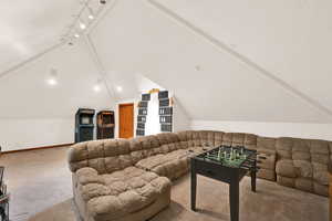 Carpeted living area featuring vaulted ceiling