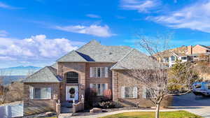 View of front of property featuring brick siding, roof with shingles, and a mountain view