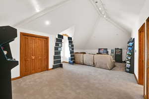 Bedroom featuring vaulted ceiling and light carpet