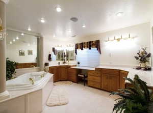Full bath featuring a garden tub, vanity, and light carpet