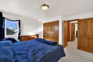 Bedroom featuring light colored carpet and a closet