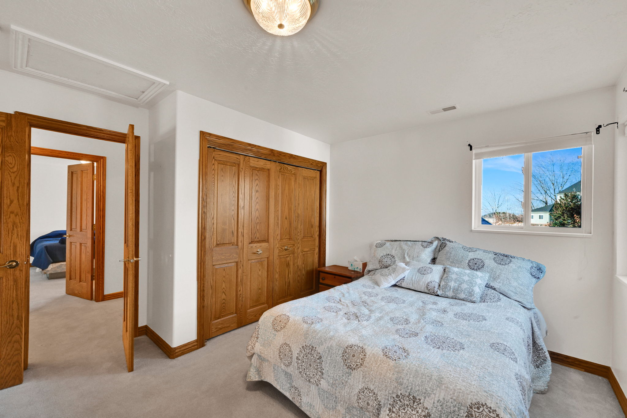 Bedroom featuring light colored carpet, a closet, and attic access