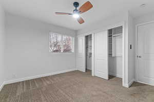 Unfurnished bedroom with multiple closets, carpet floors, and a ceiling fan