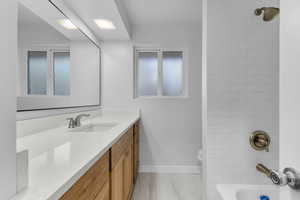 Full bathroom with vanity, shower / tub combination, and light marble finish flooring