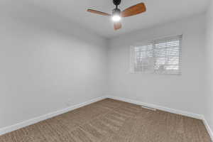 Unfurnished room featuring carpet and a ceiling fan