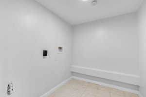 Washroom featuring washer hookup and light tile patterned floors