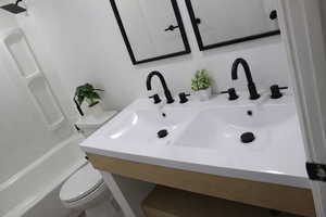 Bathroom featuring double vanity and shower / washtub combination