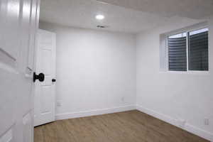 Spare room with wood finished floors and recessed lighting