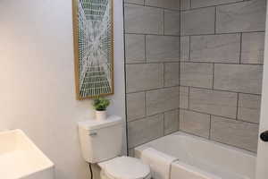 Full bathroom featuring toilet and shower / washtub combination