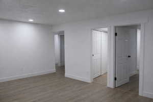 Unfurnished room featuring dark wood-type flooring, recessed lighting, and a textured ceiling