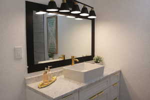 Bathroom with a textured wall and vanity