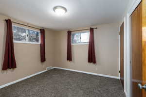 Carpeted spare room featuring baseboards