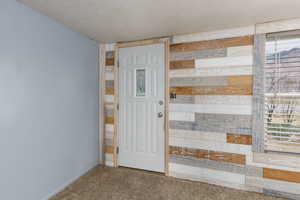Carpeted spare room featuring a textured ceiling and baseboards
