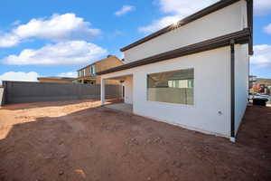 Rear view of house with stucco siding and a patio area