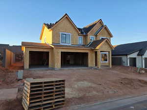View of front of house featuring stucco siding, driveway, and a patio area