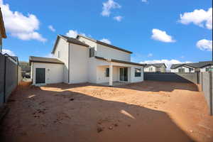 Rear view of house featuring a fenced backyard, a patio, stucco siding, and a residential view
