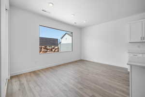 Unfurnished dining area with light wood finished floors and recessed lighting