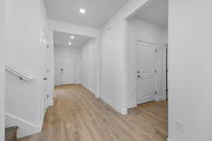 Corridor with light wood-style flooring and recessed lighting