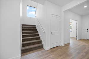 Stairs with baseboards and wood finished floors